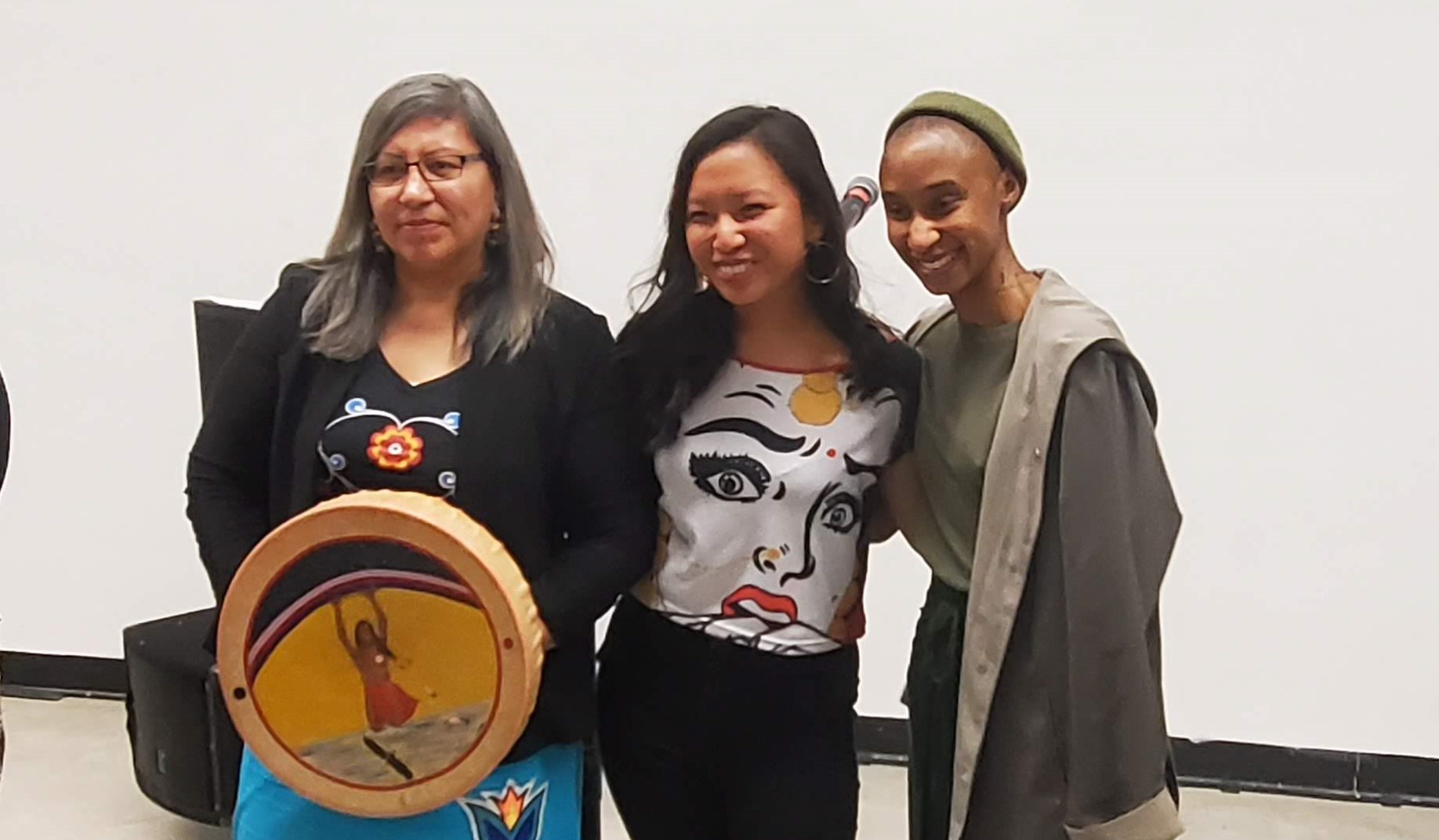 A photo of three women who opened up the 2020 FAC conferece. One is holding an aboriginal drum.