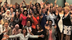 Photo of about 35 members of the Immigrant Women in Business (IWB) at an event. Founder Svetlana Ratnikova in the centre with outstretched hands. Photo provided.