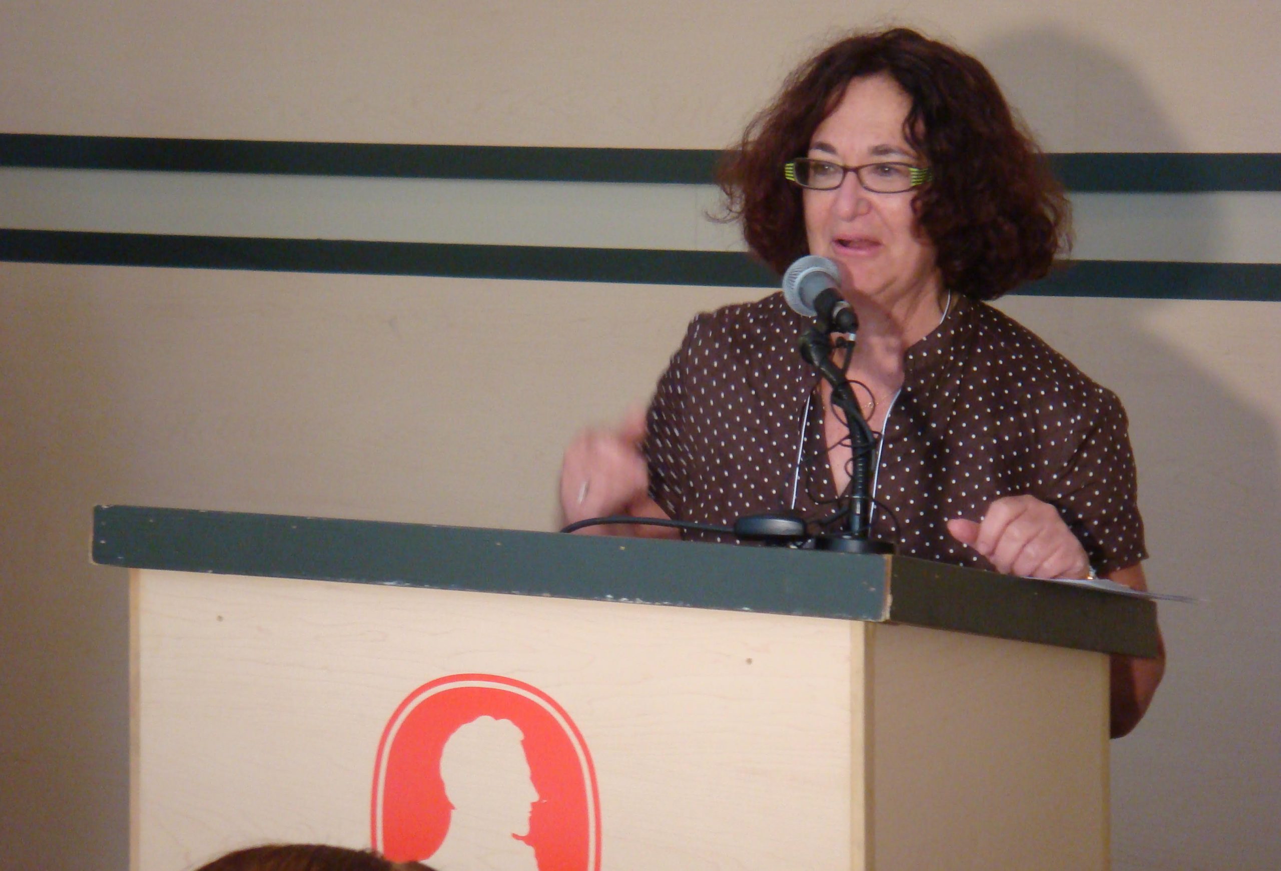 Judy Rebick speaking at a podium