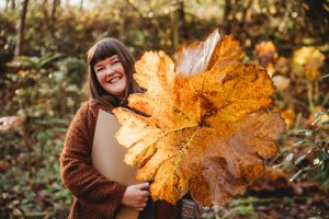 Picture of woman holding leaf in a forest