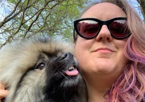 Image of woman with pink hair and her pug dog