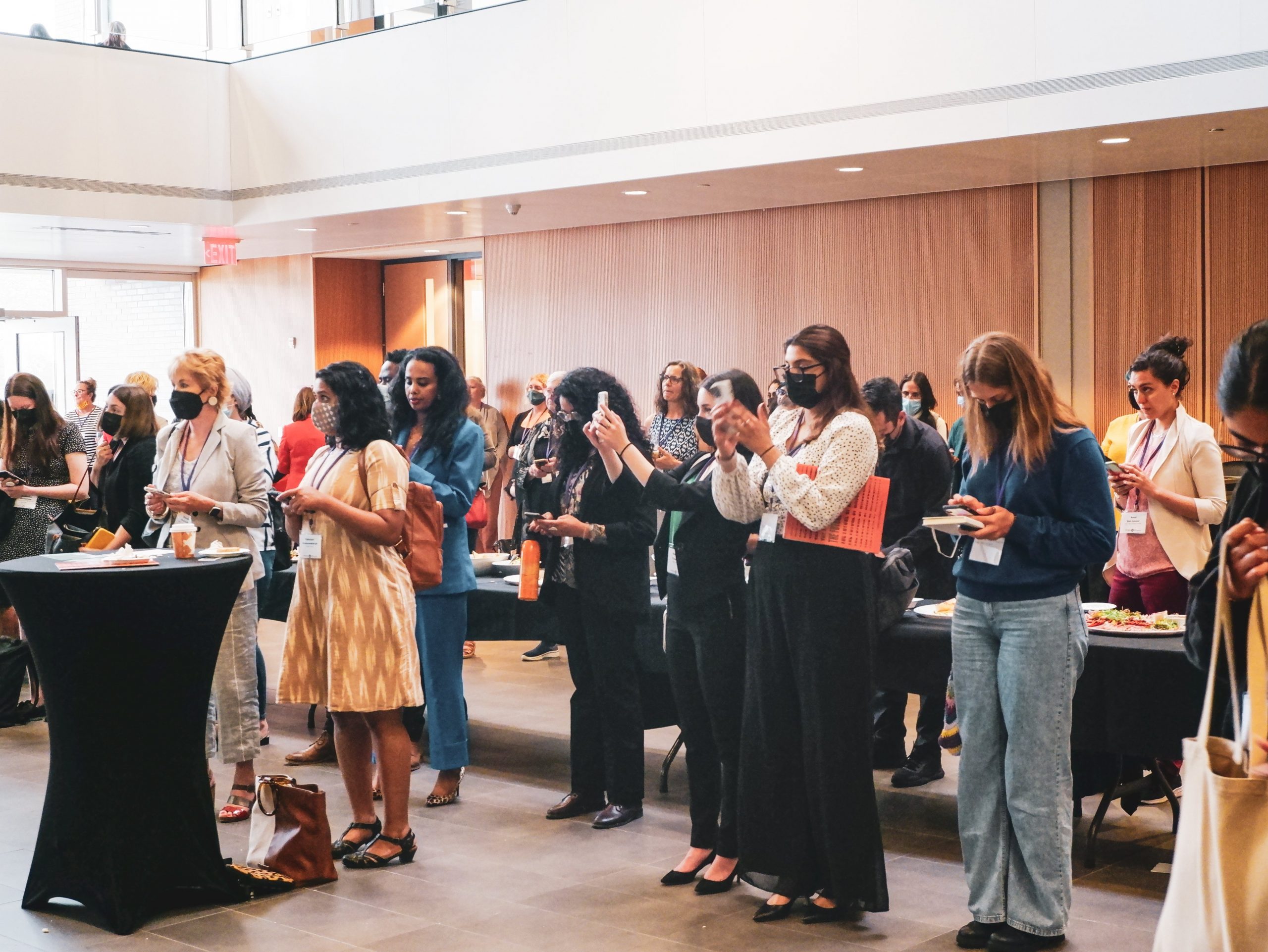 An image of diverse women facing forward to hear a speaker talk at a conference